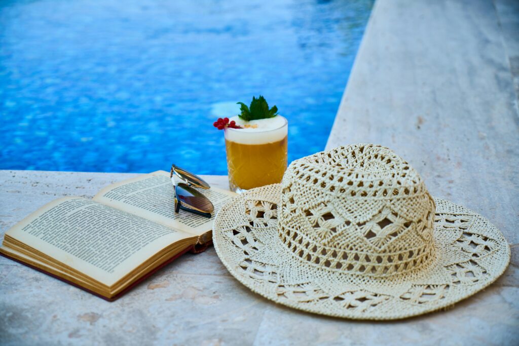 a hat by the pool with with a book and an image alcohol. What Are Alcohol Shakes? | North Star Treatment